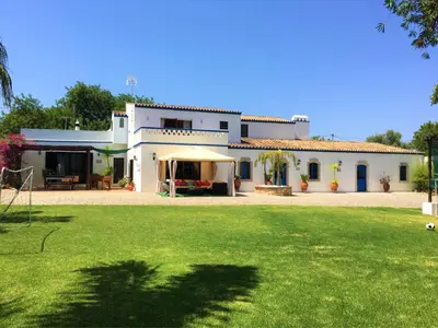 a large white house with a lawn in front of it at FARMHOUSE CASA DA AVÓ in Loulé