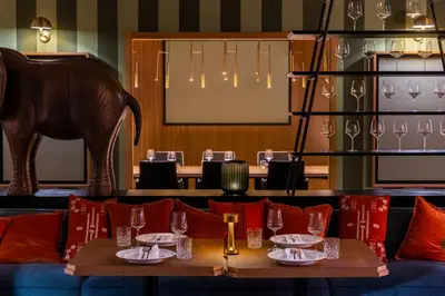 a dining room with tables and chairs and a chandelier at Wyndham Grand Algarve in Quinta do Lago