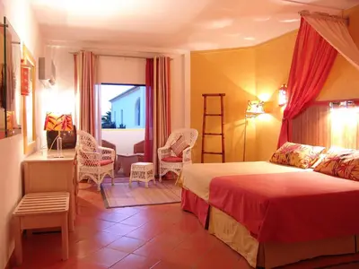 a bedroom with a bed and a table and chairs at Cerro Da Marina Hotel - Adults Only in Albufeira