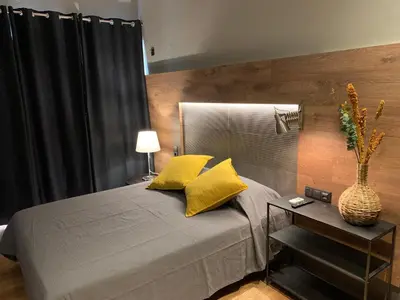 a bedroom with a bed with yellow pillows and a table at Lost & Found - Guesthouse & Suites in Albufeira