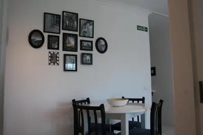 a dining room with a table and framed pictures on the wall at Apartamento com Piscina em Albufeira, Praia da Oura in Albufeira