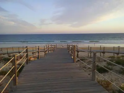 a wooden boardwalk leading to the beach at Apartamento com Piscina em Albufeira, Praia da Oura in Albufeira