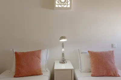 a white couch with pillows and a lamp on a table at Aldeia do Golf 151 - Clever Details in Vilamoura