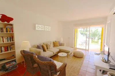a living room with a white couch and chairs at Aldeia do Golf 151 - Clever Details in Vilamoura