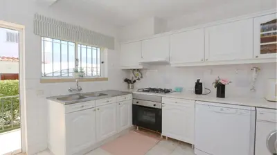 a white kitchen with white cabinets and a sink at Villa Amelia 156 - Clever Details in Vilamoura
