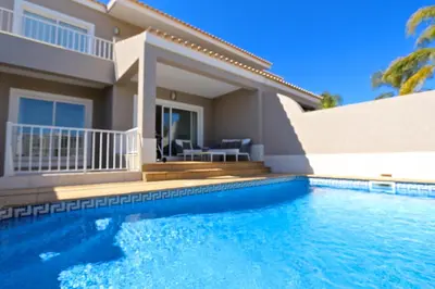 a villa with a swimming pool in front of a house at Villa Gustas 150 - Clever Details in Vilamoura