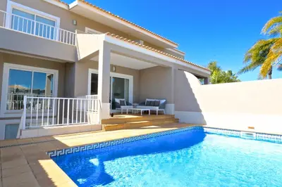 a villa with a swimming pool in front of a house at Villa Gustas 150 - Clever Details in Vilamoura