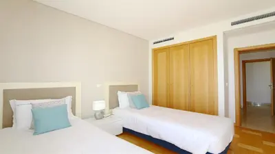 two beds in a room with white and blue at Aquamar Sea View - Clever Details in Vilamoura