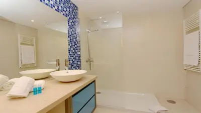 a bathroom with two sinks and a shower at Aquamar Sea View - Clever Details in Vilamoura