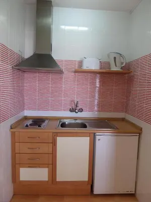 a small kitchen with a sink and a stove at Mirachoro Albufeira in Albufeira