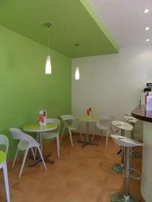 a room with tables and chairs and green walls at Mirachoro Albufeira in Albufeira