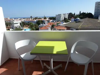a green table and two chairs on a balcony at Mirachoro Albufeira in Albufeira