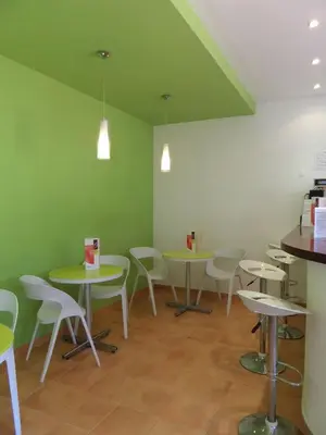 a room with tables and chairs and green walls at Mirachoro Albufeira in Albufeira