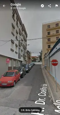 an empty city street with cars parked on the road at Palma's Place in Faro