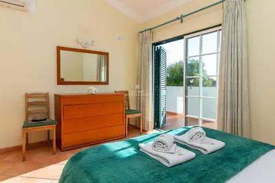 a bedroom with a bed and a dresser and a window at São Rafael Beach Villa- D´alma Rafaella in Albufeira