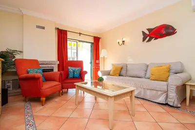 a living room with a couch and two chairs and a fishtank at São Rafael Beach Villa- D´alma Rafaella in Albufeira