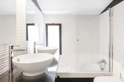 a white bathroom with two toilets and a shower at Victory Village T1 & Mezzanine in Quinta do Lago
