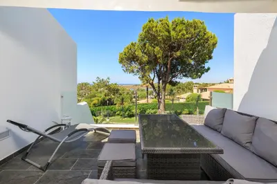 a living room with a couch and a table and a tree at Victory Village T1 & Mezzanine in Quinta do Lago
