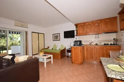 a kitchen and a living room with a couch at Casa Flor in Vilamoura