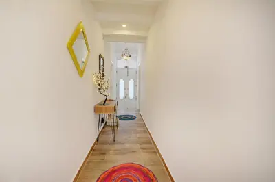 a hallway with a white wall and a rug at Blue Barqueta Studio in Faro
