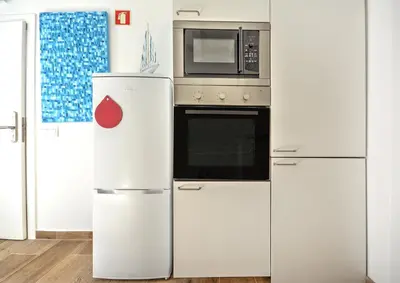 a kitchen with a refrigerator and a microwave at Blue Barqueta Studio in Faro