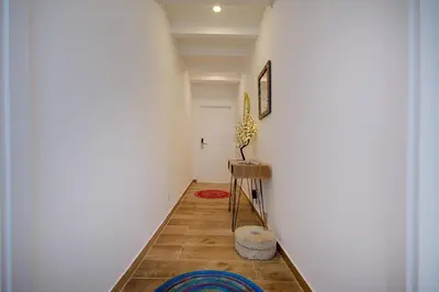 a hallway with a white wall and a table at Terrace Barqueta Studio in Faro