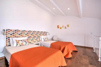 a bedroom with two beds and an orange blanket at Terrace Barqueta Studio in Faro