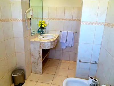 a bathroom with a sink and a mirror and a toilet at Villa Esmeralda in Albufeira