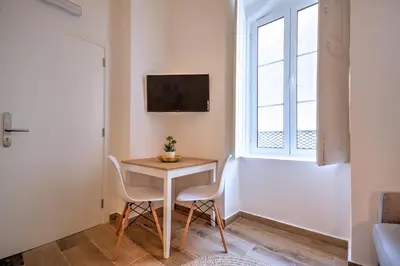 a small table and chairs in a room with a window at Yellow Barqueta Studio in Faro