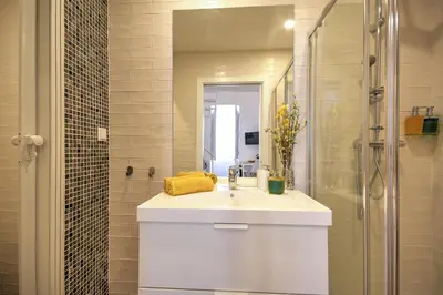 a white bathroom with a sink and a mirror at Yellow Barqueta Studio in Faro