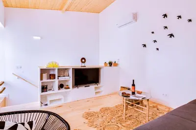 a living room with a couch and a tv at A Casa D'Amelie in Faro