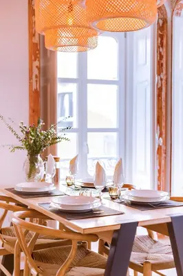 a dining room table with plates and utensils on it at A Casa D'Amelie in Faro