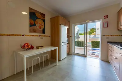 a kitchen with a table and a refrigerator at Boutique & Villas Boliqueime in Boliqueime