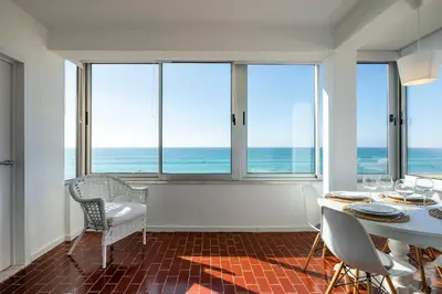 a dining room with a view of the ocean at Ria Beach House in Faro