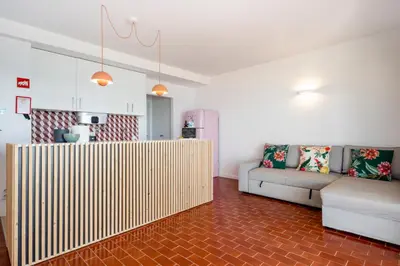 a living room with a couch and a table at Ria Beach House in Faro