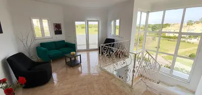 a living room with a staircase and a green couch at Sunset Villa by Laranjal Rentals in Olhos de Água