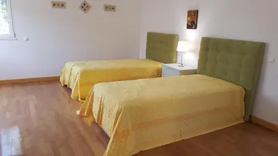a hotel room with two beds and a lamp at Sunset Villa by Laranjal Rentals in Olhos de Água