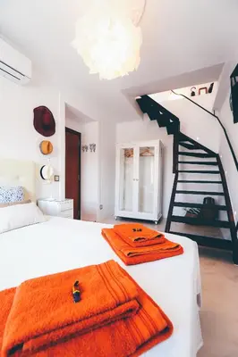 a bedroom with a bed and a spiral staircase at Studio Sal in Albufeira