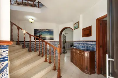 two blue chairs sitting on the grass near a house at Residential cul-de-sac walking distance to centre, private pool, free AC wifi in Loulé