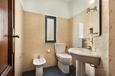 a bathroom with a toilet and a sink at Residential cul-de-sac walking distance to centre, private pool, free AC wifi in Loulé