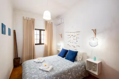 a bedroom with a bed with blue pillows and two plates on it at #003 Cottage By Home Holidays in Albufeira