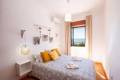 a bedroom with a bed with yellow pillows and a window at #003 Cottage By Home Holidays in Albufeira