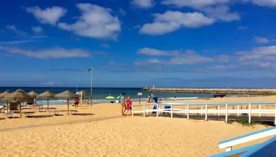 a beach with umbrellas and people on the beach at Seastar in Vilamoura