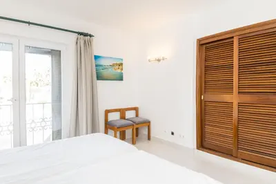 a bedroom with a bed and a window and a chair at Great S.Rafael Aprt. walking distance to the beach in Albufeira