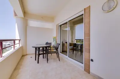 a room with a table and chairs and a balcony at Avelãs - Modern apartment - Vilamoura in Vilamoura
