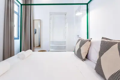 a white bedroom with a large white bed with two pillows at Alameda Exclusive House in Faro