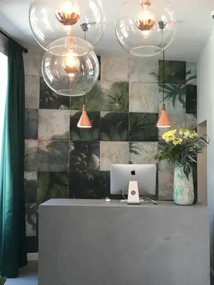 a reception desk with a laptop and two chandeliers at Alameda Exclusive House in Faro
