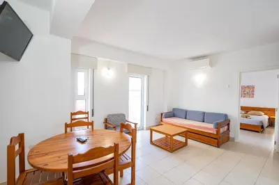 a living room with a table and a couch at Edifício Sequeira - Alojamento Local by Umbral in Albufeira