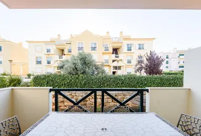 a table on a balcony with a view of a building at Quinta do Paiva - Jardins do Vale in Roja- Pé