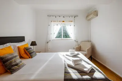 a bedroom with a large white bed and a window at Quinta do Paiva - Jardins do Vale in Roja- Pé